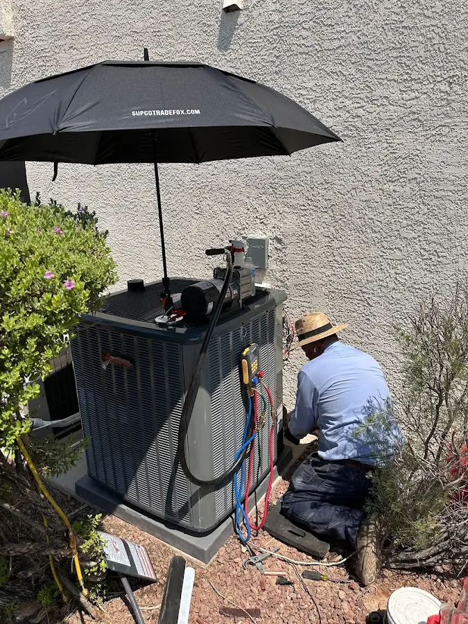 HVAC technician performing outdoor AC maintenance in Greensburg