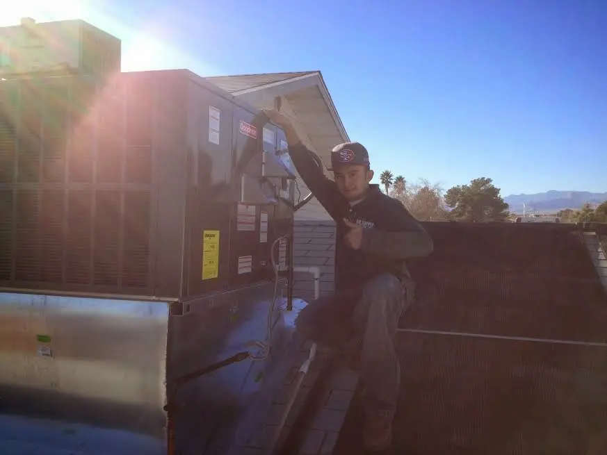 HVAC technician performing HVAC Inspection on a rooftop unit in Greensburg